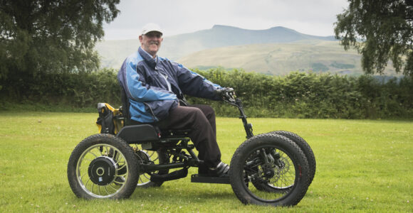 Man riding tramper at national park visitor centre with pen y fan as the back drop